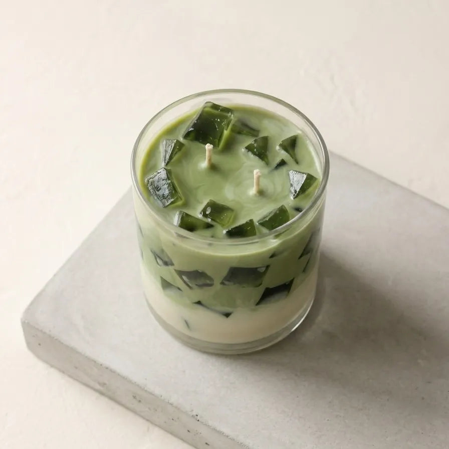 A beautiful top-down close-up shot highlighting the smooth cream and soft green wax detailing of the handcrafted iced matcha latte candle