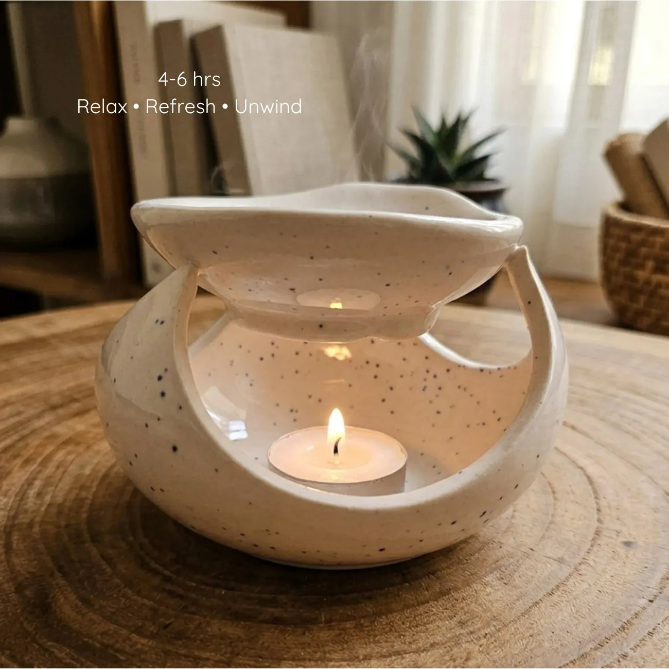A white ceramic diffuser lit by a warm tealight candle inside, casting soft shadows while melting an aromatherapy wax sachet on top