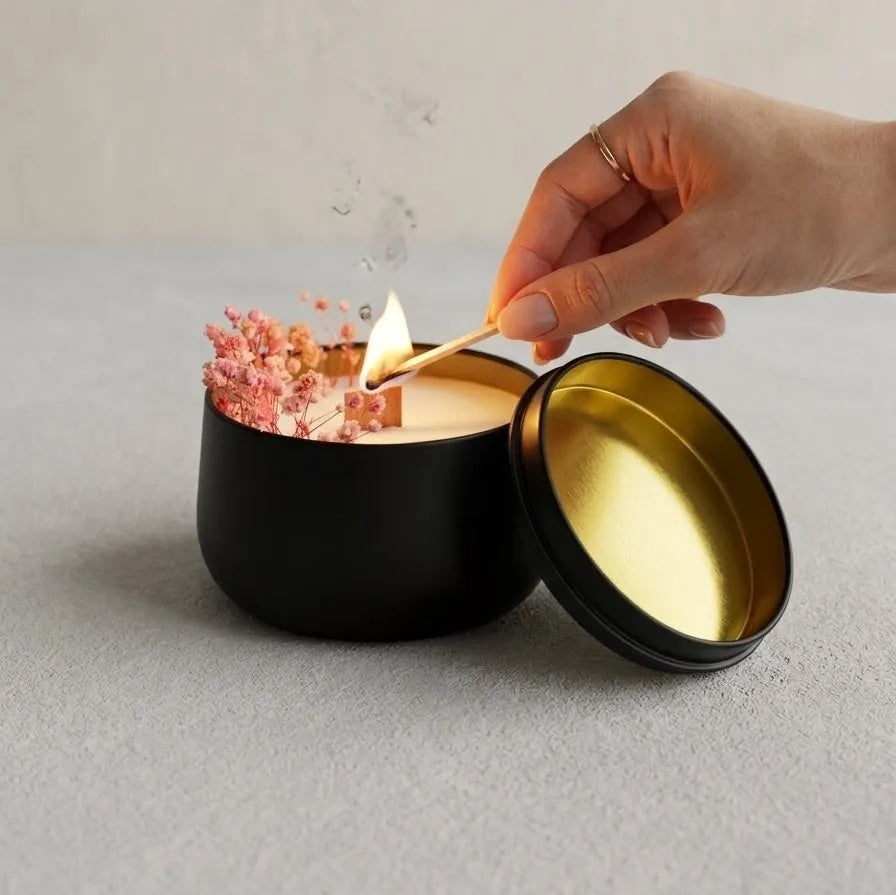 The premium round black tin candle displayed side-by-side with its matching sleek black lid, showcasing a minimal and sober brand design