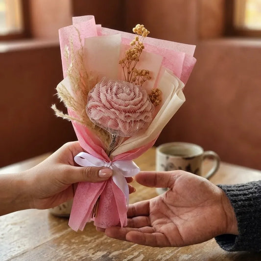 The elegant pink shaded peony bouquet candle styled as a minimal, sober centerpiece on a modern living room table setup